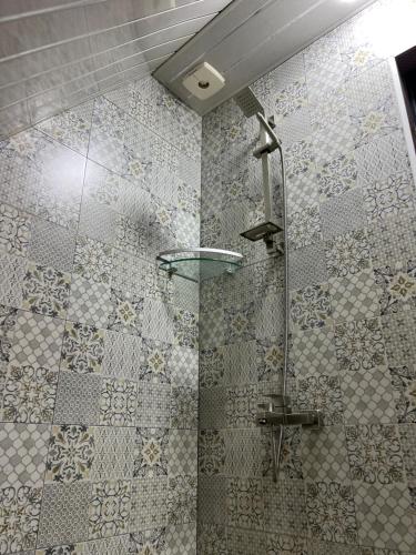 y baño con ducha y pared de azulejos. en Dream Panorama Cottage, en Batumi