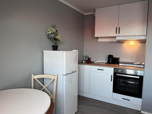 een kleine keuken met een witte koelkast en een tafel bij cozy studio apartment in Trondheim