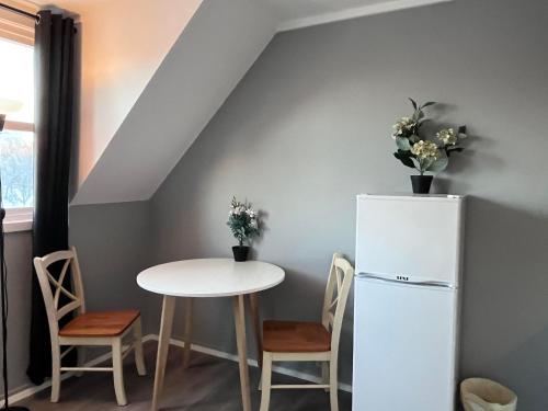 een keuken met een tafel en een witte koelkast bij cozy studio apartment in Trondheim