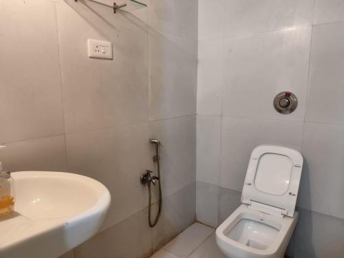 a bathroom with a toilet and a sink at Palm Heaven in Canacona