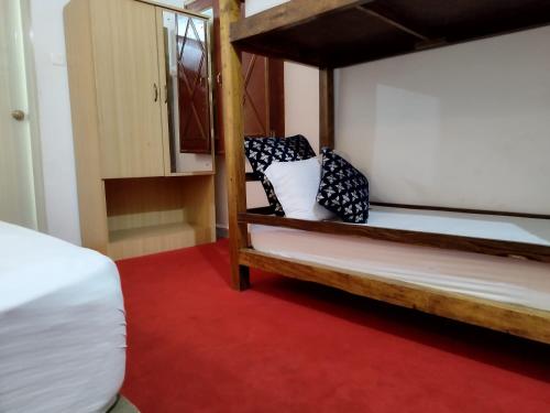 1 dormitorio con 2 literas y alfombra roja en Palm Heaven en Canacona