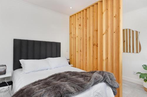 a bedroom with a bed with a wooden headboard at Chic Studio Apartment Mountain views Gardens in Cape Town