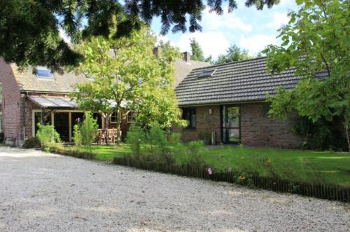 a brick house with a garden in front of it at Het Achterhuis in Siebengewald