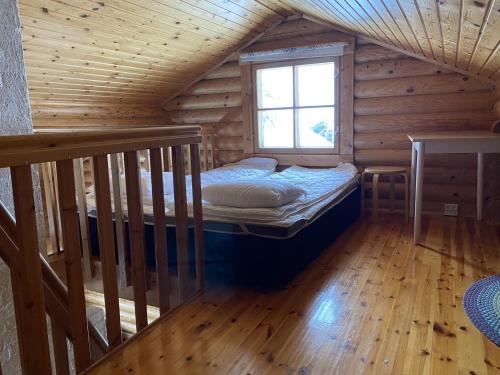 um quarto com uma cama num chalé de madeira em Kuusivilla 1 em Syöte