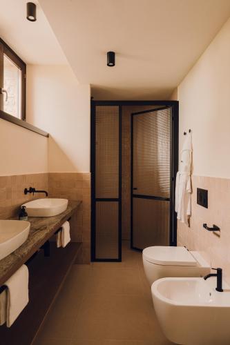 a bathroom with two sinks and two toilets at Aethos Saragano in Saragano