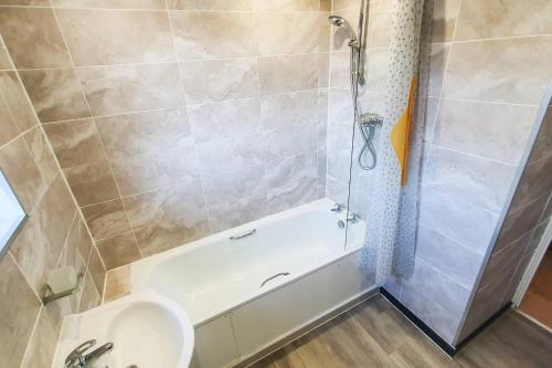 a bathroom with a tub and a toilet and a shower at Captivating 4-Bed House in Cheltenham in Cheltenham