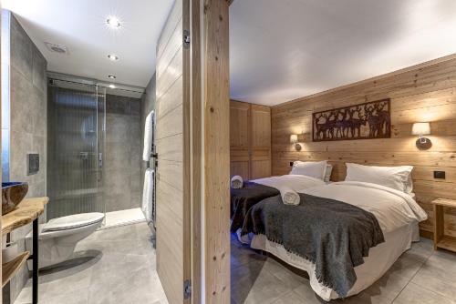a bedroom with a bed and a shower and a toilet at Chalet des Sapins in Chamonix-Mont-Blanc