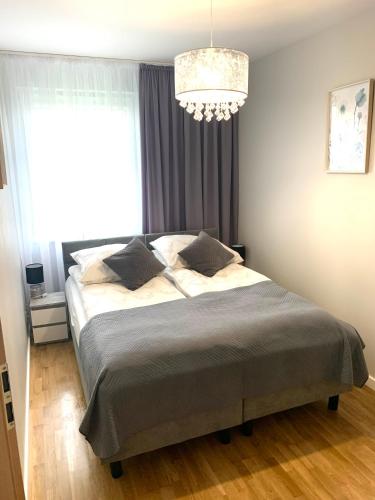 Schlafzimmer mit einem Bett und einem Kronleuchter in der Unterkunft Apartament Manhattan in Gorzów Wielkopolski