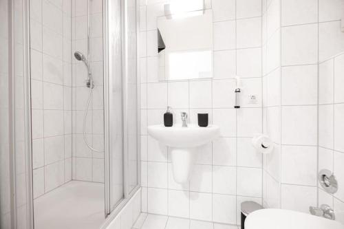 bagno bianco con lavandino e doccia di EXKLUSIVE 2-Zimmer Wohnung Bremen Neustadt 4 Pers. a Brema