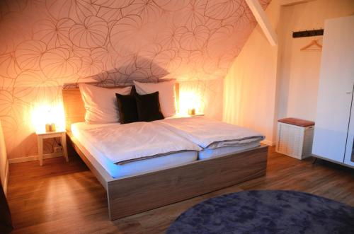 ein Schlafzimmer mit einem Bett mit zwei Lampen in der Unterkunft Ferienhaus zum Glück in Gerswalde
