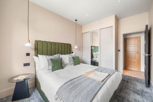 a bedroom with a large bed with a green headboard at Kentish Town Road in London