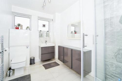 Spacious modern family bedroom in Central London في لندن: حمام مع دش ومغسلة ومرحاض