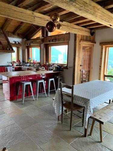une cuisine avec une table et des chaises dans une cuisine dans l'établissement La Rosière Magnifique chalet savoyard 160 m2 T5, à Montvalezan