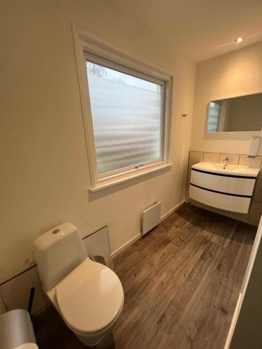 La salle de bains est pourvue de toilettes, d'un lavabo et d'une fenêtre. dans l'établissement Gæstehus, à Gråsten