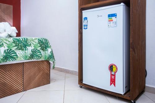 a refrigerator sitting next to a chair in a room at Pousada Castelinho in São Sebastião