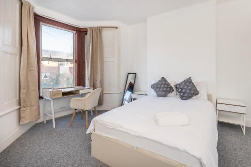 a bedroom with a bed and a desk and a window at Bright Guest house in Stratford in Stratford