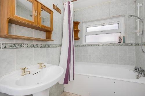 a bathroom with a sink and a bath tub at Bright Guest house in Stratford in Stratford