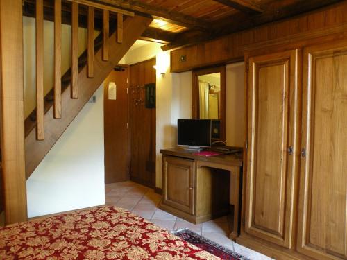 a bedroom with a bed and a desk with a computer at Hotel Bellevue in Champoluc