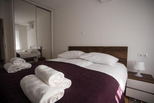 een slaapkamer met een groot bed met handdoeken erop bij Apartman Domagoj in Osijek