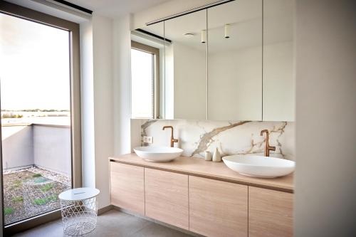a bathroom with two sinks and a large window at KAOZ Highstreet The Luxury Loft in Antwerp