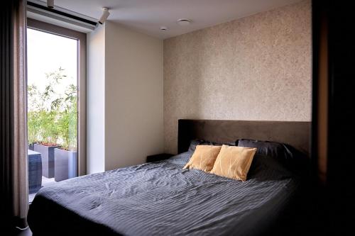 een slaapkamer met een bed en een groot raam bij KAOZ Highstreet The Luxury Loft in Antwerpen