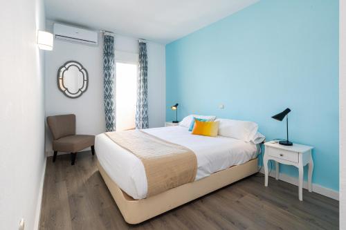 a bedroom with a large bed and a chair at Holidays2Benal Beach Terraza Solarium in Benalmádena
