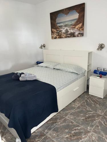 una camera da letto con un letto bianco con una coperta blu di La Cascada 410 a Puerto Rico de Gran Canaria