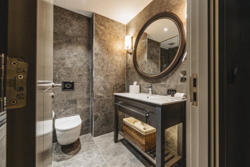 a bathroom with a sink and a toilet and a mirror at Dakota Leeds in Leeds