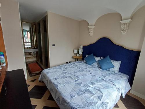 Espana condo resort Pattaya by BovyRentel في جومتين بيتش: غرفة نوم مع سرير أزرق مع اللوح الأمامي الأزرق