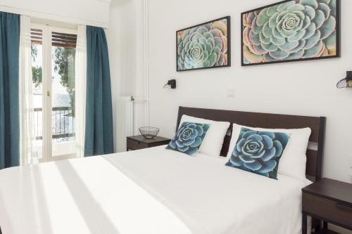 um quarto com uma cama branca e almofadas azuis em Seafront Apartment in Piraeus em Piraeus
