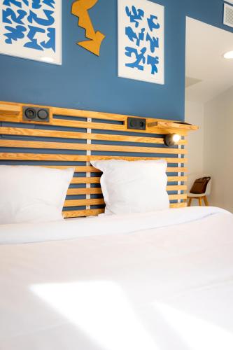 a bedroom with a bed with a blue wall at The People - Marseille in Marseille