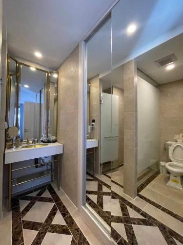 a bathroom with a toilet and two sinks and a mirror at Espana condo resort Pattaya by BovyRentel in Jomtien Beach