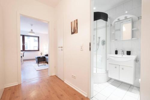 uma casa de banho branca com um chuveiro e um lavatório. em EXKLUSIVE 2-Zimmer Wohnung Bremen Neustadt 6 em Bremen