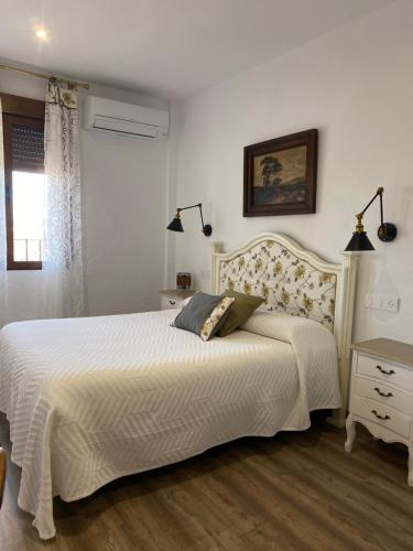 a bedroom with a white bed and a window at Casa Rural Dolly Baby in Alarcón