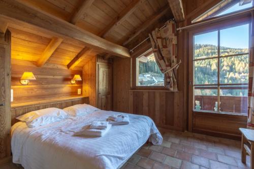 a bedroom with a bed in a room with a window at les ours in La Plagne Tarentaise