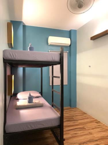 a bunk bed in a room with a blue wall at Outpost Hostel - Coron in Coron