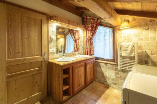 a bathroom with two sinks and a large mirror at les ours in La Plagne Tarentaise