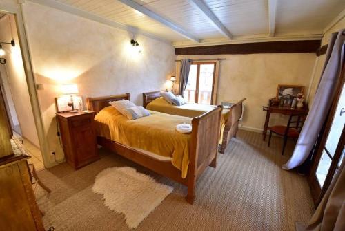 a bedroom with a bed and a table and a window at Maison au coeur des Bauges in Aillon-le-Jeune