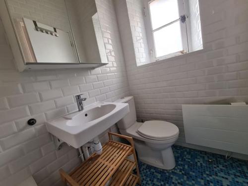 a white bathroom with a sink and a toilet at La Clé de Laurent - 2 pièces Haussmannien in Versailles