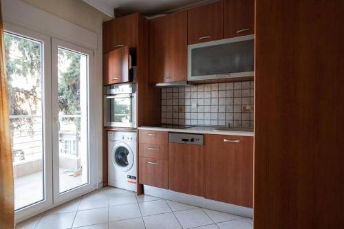 kuchnia z pralką i suszarką oraz okno w obiekcie Cozy apartment in Sykies w Salonikach