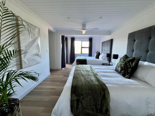 ein Hotelzimmer mit 2 Betten und einem Sofa in der Unterkunft The Milkwoods Luxury Living in Mossel Bay