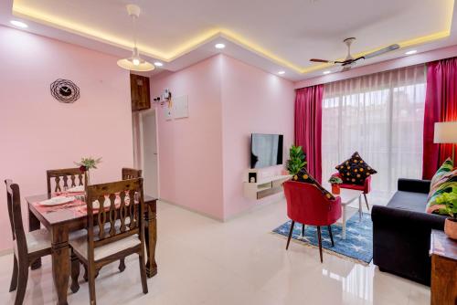 a living room with a table and a dining room at Cozy 2BHK 4km from GOI airport - 15 min to Cansaulim Beach South Goa - Swimming pool access in Dabolim