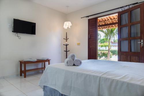 a bedroom with a bed with towels on it at Pousada Villa Martins in São Miguel do Gostoso