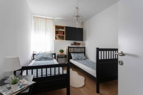um pequeno quarto com duas camas e uma mesa em 2-Bedroom Apt Near City Center em Zagreb