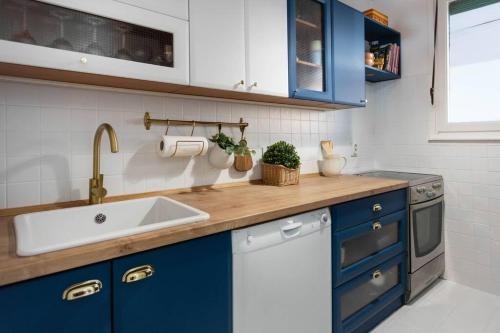 uma cozinha com armários azuis e um lavatório em 2-Bedroom Apt Near City Center em Zagreb