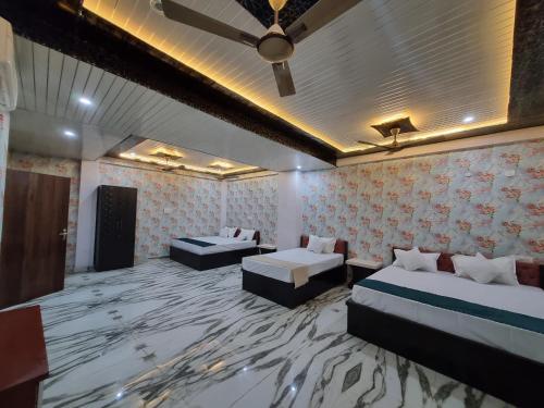 a hotel room with two beds and a ceiling at Hotel Vinayak Plaza in Varanasi