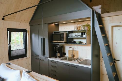 una pequeña cocina con fregadero y escalera en TinyLodge 6, en Heilbad Heiligenstadt