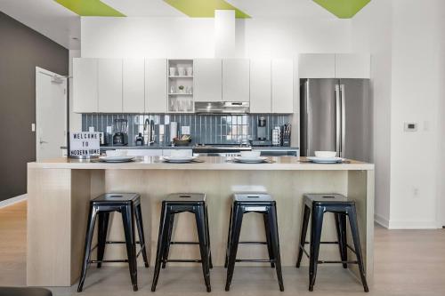 a kitchen with a large island with four bar stools at Modern Home 3BD/3BA Free On-Street Parking & Wi-fi in Baltimore