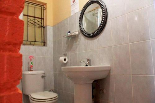 a bathroom with a sink and a toilet and a mirror at RIO GUESTHOUSE in Maseru