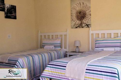 two beds sitting next to each other in a room at RIO GUESTHOUSE in Maseru